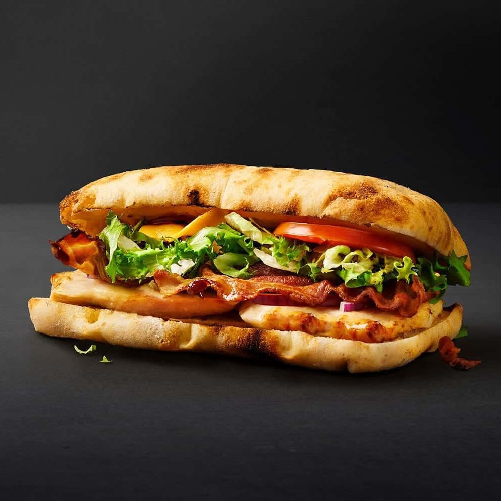 En lækker grilled sandwich med saftig kylling og sprød bacon.